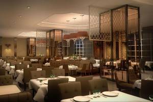 Innenansicht des Restaurants im Vogue Hotel Supreme Bodrum mit runden Tischen und Stühlen, goldenen Kronleuchtern und gemusterten Trennwänden.
