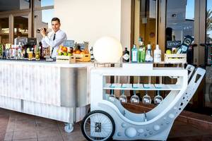 Ein Barwagen vor dem Occidental Jandia Mar Hotel mit verschiedenen Getränken und Früchten.