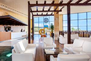Empfangsbereich im Occidental Jandia Mar Hotel mit Rezeptionstresen und Loungestühlen.