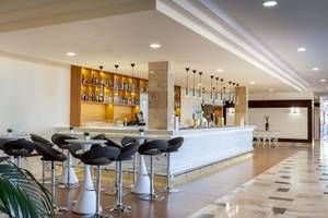 Innenansicht der Bar im Occidental Jandia Mar Hotel mit Barhockern, Theke und Pflanzen.