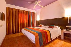 Hotelzimmer im SBH Monica Beach Resort mit Doppelbett, Deckenventilator und Nachttisch.
