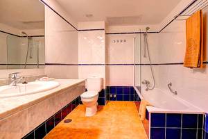 Badezimmer im SBH Monica Beach Resort mit Badewanne, Toilette und Waschbecken.