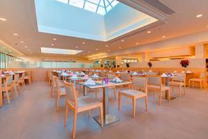 Restaurant des SBH Monica Beach Resorts mit hellem Interieur und runden Tischen