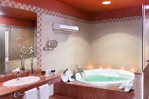 Badezimmer im Occidental Jandia Royal Level mit Badewanne, Dusche und Spiegel.