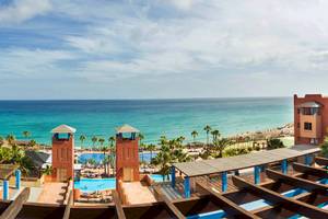 Aussicht auf das Meer vom H10 Tindaya Hotel aus, mit Gebäuden und Swimmingpools.