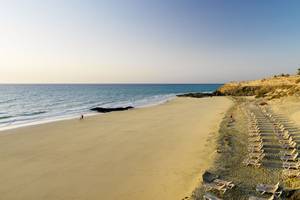 Strand des H10 Tindaya Hotels mit weißen Sonnenliegen und blauem Meer