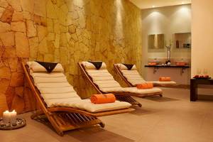 Spa-Lounge im Melia Tortuga Beach Hotel mit drei Liegestühlen und Kerzen.