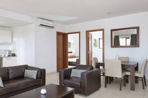Wohnzimmer im Melia Tortuga Beach Hotel mit braunen Möbeln und weißer Wandgestaltung.