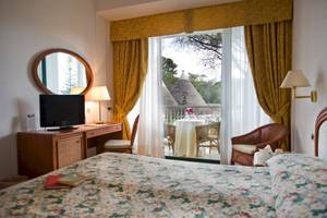 Ein Schlafzimmer im Sierra Silvana Hotel mit Blick auf eine Terrasse und traditionelle Gebäude.