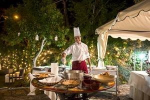 Ein Koch im Sierra Silvana Hotel bereitet ein Essen unter freiem Himmel in der Nacht zu.