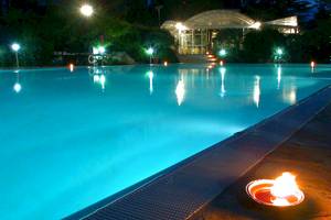 Ein Pool bei Sierra Silvana Hotel in der Nacht mit blauem Wasser und Lichtern.