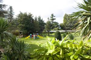 Spielplatz im Freien des Sierra Silvana Hotels mit gelben Rutschen und bunten Spielgeräten