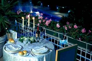 Ein elegantes Abendessen auf der Terrasse des Sierra Silvana Hotels mit Kerzen und Blick auf den Pool.