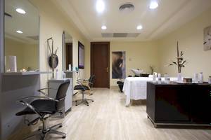 Friseursalon im Hipotels Hipocampo Palace mit hellen Wänden, Holzboden und mehreren Stühlen.