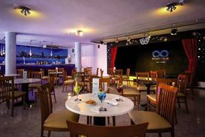 Innenbereich des Bahia Flamingo Hotels mit gepolsterten Stühlen, Tischen und einer Bar im Hintergrund.