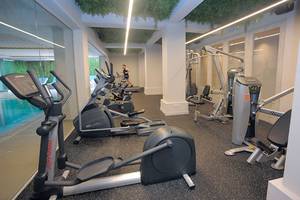 Innenansicht des Fitnesscenters im Nelia Beach Hotel & Spa mit Laufband und Hantelbank.