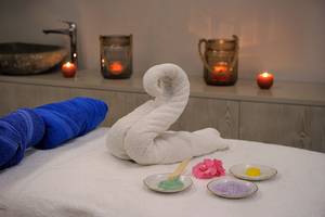 Massagetisch im Spa des Nelia Beach Hotel mit Handtüchern und Pflegeprodukten.