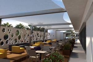 Terrasse des Nelia Beach Hotel & Spa mit Tischen, Stühlen und Pflanzen