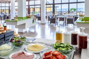 Buffet-Restaurant im Occidental Jandia Playa Hotel mit einer Auswahl an Salaten, Tomaten, Gurken, Schinken, Brot und Dressings.