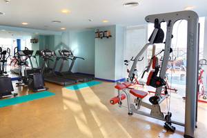 Fitnessstudio im Occidental Jandia Playa Hotel mit diversen Geräten und Spiegeln.