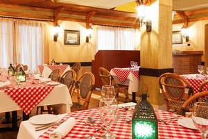 Innenansicht eines Restaurants im Jaz Lamaya Resort mit rot-weiß karierten Tischdecken.