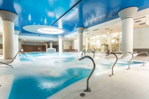 Innenpool des Landmar Costa Los Gigantes Hotels mit blauer Decke und Wasserstrahlen.
