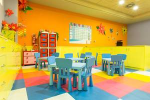 Foto von einem bunten Kinderzimmer im Landmar Costa Los Gigantes Hotel mit Tisch, Stühlen und dekorativen Wandelementen.