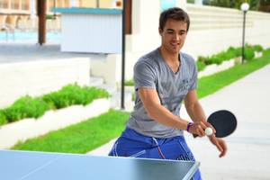 Mann im Messonghi Beach Holiday Resort spielt Tischtennis.