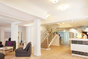 Whala Beach Hotel Innenbereich mit Wohnzimmer, Couches, Tisch und Treppenhaus