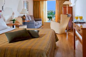 Hotelzimmer von Giannoulis Santa Marina Beach mit Bett, Sofa, Stühlen und Ausblick.