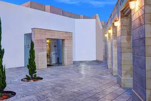 Eingang des Giannoulis Santa Marina Beach Hotels mit gepflastertem Boden und Pflanzen