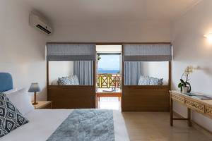 Schlafzimmer im Mitsis Ramira Beach Hotel mit Blick auf den Balkon und das Meer.