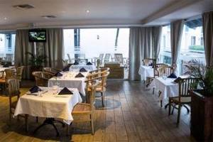 Das geräumige Restaurant des Mill Resort & Suites mit vielen Tischen und Stühlen.