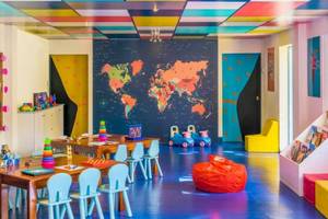 Kinderzimmer im Le Meridien Ile Maurice mit bunten Möbeln und einer Weltkarte an der Wand.