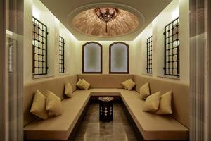 Lounge Bereich im Titanic Deluxe Golf Belek Hotel mit runden Sofas und Fenstern.