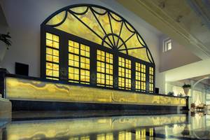 Empfangsbereich des Titanic Deluxe Golf Belek Hotels mit großem Fenster und gelben Marmor.
