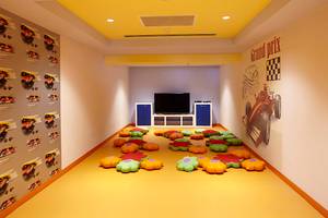 Spielzimmer im Titanic Deluxe Golf Belek Hotel mit Fernseher, bunten Kissen und Rennwagen-Wandaufklebern