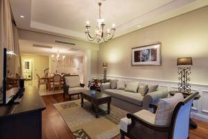 Wohnzimmer im Titanic Deluxe Golf Belek Hotel mit Sofa, Tisch und Fernseher.