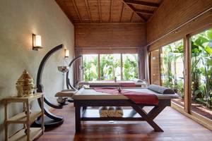 Spa-Massageraum im Titanic Deluxe Golf Belek mit Holzboden, Massagetischen und großen Fenstern.