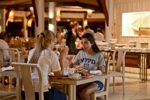 Zwei Frauen essen im Restaurant des Bandos Maldives Hotel.