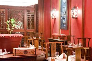 Innenraum des Makadi Spa Hotels mit Tisch und Stühlen, roter Wand und Lampen.