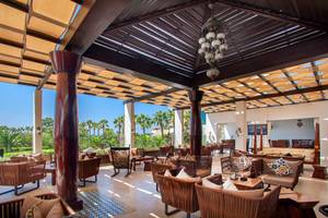 Loungebereich im GrandResort Limassol mit Holzmöbeln und Deckenlampen.