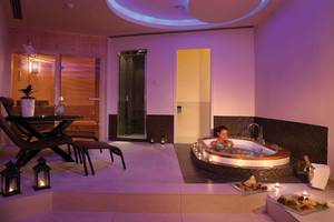 Innenansicht der Jacuzzi-Lounge im GrandResort Limassol mit einer Frau im Whirlpool.