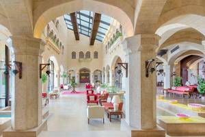 Die geräumige und helle Halle des Kempinski Hotel Soma Bay mit Säulen, Sitzgelegenheiten und Pflanzen.