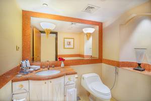 Badezimmer im Sheraton Abu Dhabi Hotel mit Spiegel, Waschbecken, Toilette und Dekoration.