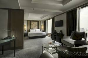 Hotelzimmer im Banyan Tree Bangkok mit einem großen Bett, Schreibtisch, Fernseher und Wohnzimmermöbeln.