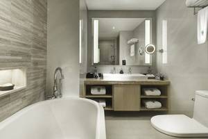 Modernes Badezimmer im Banyan Tree Bangkok Hotel mit Badewanne, Waschbecken und Toilette.