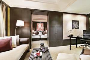 Innenansicht der Suite im Banyan Tree Bangkok mit Wohnzimmer, Schreibtisch und Schlafzimmerbereich.