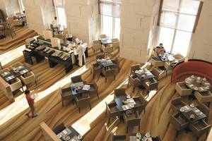 Restaurant im Shangri-La Hotel in Dubai mit vielen Tischen und Stühlen, serviertem Essen und Gästen.