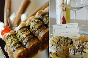 Nahrungsmittel und Getränke im Cactus Royal Hotel, einschließlich Desserts mit Schokolade und Pistazien sowie Gläser mit Wein.
